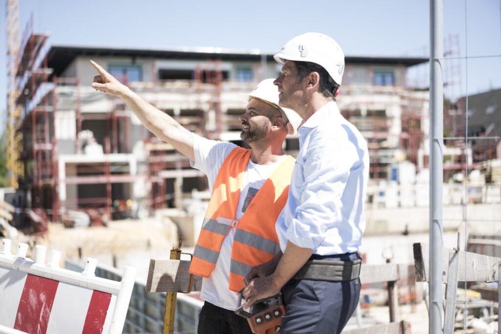 JT Engenharia Civil | Home Construction worker talking to man on construction site